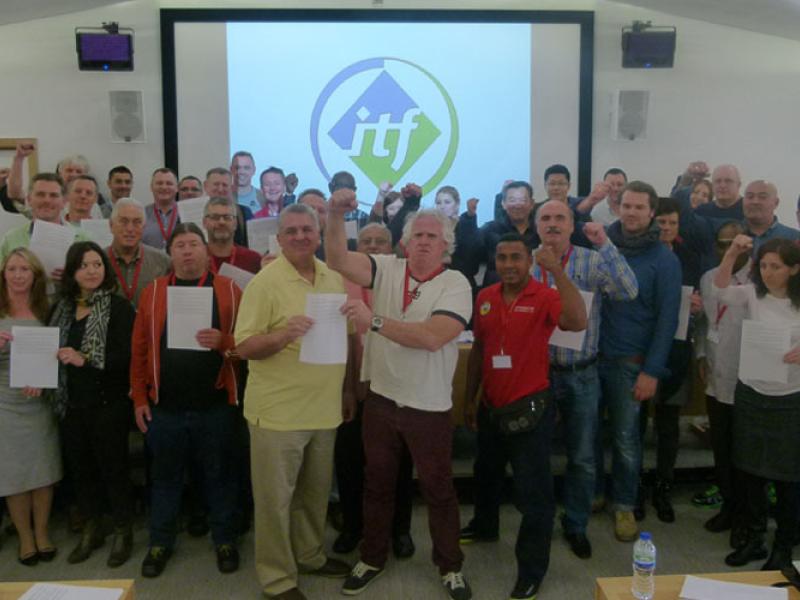 Delegates at today’s meeting hold up the pledge to back the ILWU