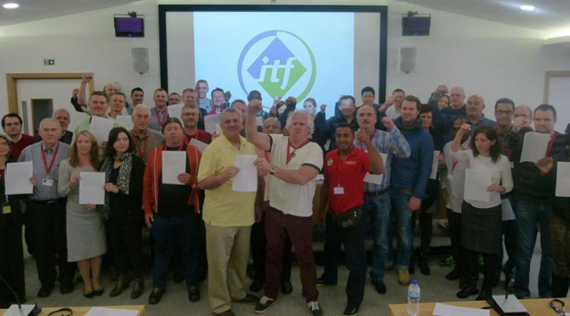 Delegates at today’s meeting hold up the pledge to back the ILWU